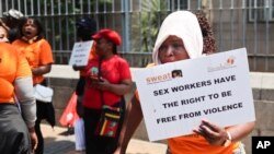 Women's rights group members protest outside the Johannesburg Magistrates court in downtown Johannesburg, South Africa, Tuesday, Oct. 11, 2022. 