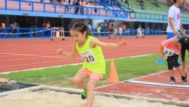A young athlete jumps during a competition.
