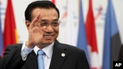 FILE - China's Premier Li Keqiang waves as he arrives at Milan's International fair for the ASEM summit of European and Asian leaders, in Milan, Italy, October 2014.