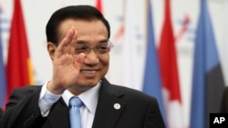 China's Premier Li Keqiang waves as he arrives to Milan's International fair for the second day of a ASEM summit of European and Asian leaders, in Milan, Italy, Friday, Oct. 17, 2014.