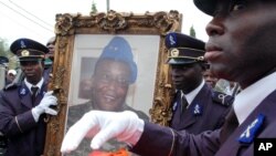 Des soldats tiennent le portrait de Robert Guéï à Abidjan, le 18 août 2006. (AP Photo)