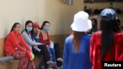 FILE - Garment workers rest inside a factory after their lunch break in Phnom Penh.