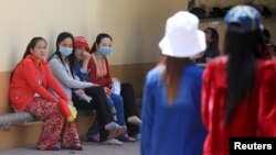 FILE - Garment workers rest inside a factory after their lunch time in Phnom Penh.