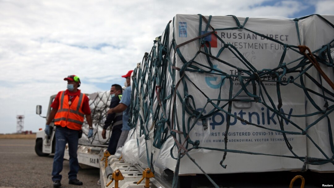 Para pekerja usai menurunkan kiriman pertama vaksin COVID-19, Sputnik V, buatan Rusia di Bandara Internasional Caracas, Venezuale, 13 Februari 2021. (Foto: Reuters)
