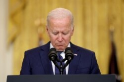 Presiden AS Joe Biden mengheningkan cipta untuk para korban tewas saat menyampaikan pidato tentang Afghanistan, dari Ruang Timur Gedung Putih di Washington, AS 26 Agustus 2021. (Foto: REUTERS/Jonathan Ernst)