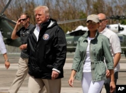 FILE - President Donald Trump and first lady Melania Trump walk after arrival at the Luis Muniz Air National Guard Base in San Juan, Puerto Rico, Oct. 3, 2017.