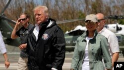 President Donald Trump and first lady Melania Trump walk after arrival at the Luis Muñiz Air National Guard Base in San Juan, Puerto Rico, Oct. 3, 2017.. 