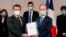 Historian and Commission chief on the France's role in 1994's Rwandan genocide, Vincent Duclert, right, gives a report to French President Emmanuel Macron, at the Elysee Palace, in Paris, March 26, 2021. 