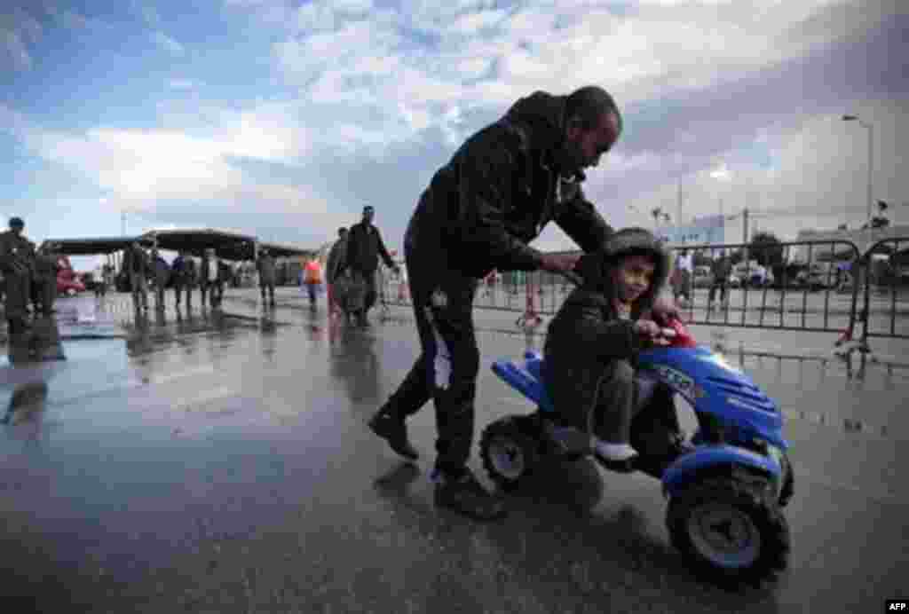 Tunisians walk after they fled from Libya at the Tunisia-Libya border, near the village of Ras Ajdir, Tunisia, Wednesday, Feb. 23, 2011. (AP Photo/Lefteris Pitarakis)