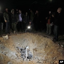 A crater, which the Libyan government said was caused by coalition air strikes, is seen at an area in Bab al-Aziziyah compound in Tripoli, April 23, 2011 (picture taken on guided government)