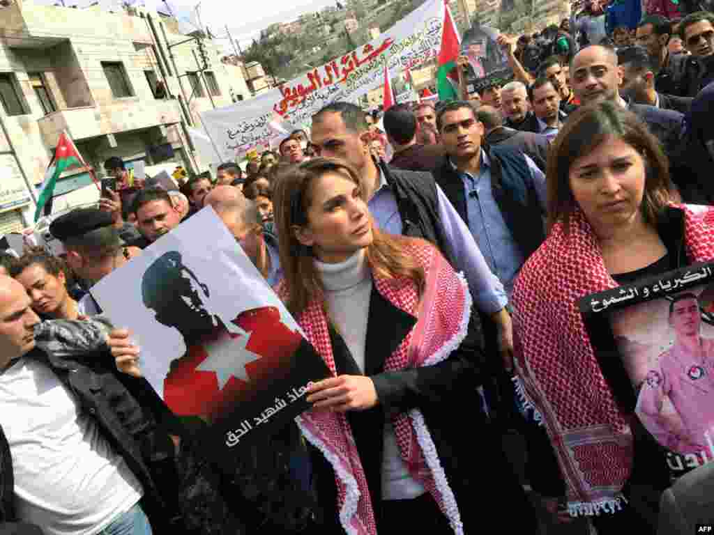 A handout picture released by the Jordanian Queen Rania&#39;s office shows her holding a placard during a demonstration in the capital Amman to express her solidarity with the pilot murdered by the Islamic State (IS) group.