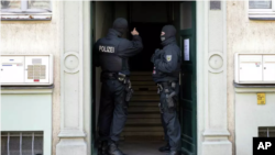 Agentes de policía se ven en la entrada de un edificio durante un cateo en una operación contra supuestos miembros de una organización armada de ultraderecha en Dresde, Alemania, el 5 de noviembre de 2024