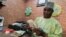 FILE - A bureau de change operator counts U.S. currency notes in Abuja, March 12, 2015. 