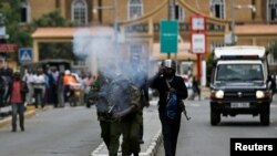 Des policiers anti-émeutes tirent des gaz lacrymogènes pour disperser les partisans de la coalition de la Super Alliance Nationale (NASA) au Kenya lors d'une manifestation le long d'une rue à Nairobi, Kenya, 24 octobre 2017.