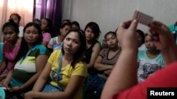 FILE - Women listen during a family planning lecture by a Likhaan NGO health worker at a reproductive health clinic in Tondo, metro Manila, Philippines, Jan. 12, 2016.