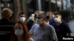 Vérification de la température des personnes qui entrent dans le centre commercial de la Nouvelle-Amérique à Rio de Janeiro, le 11 juin 2020. (REUTERS/Ricardo Moraes)