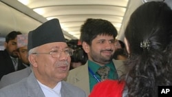 Prime Minister Madhav Kumar Nepal (L) greets fellow passengers aboard a commercial flight from Bhutan to Kathmandu (FILE)