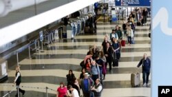 A long line of travelers wait for the TSA security check point at O'Hare International airport, Monday, May 16, 2016, in Chicago. 