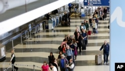 A long line of travelers wait for the TSA security check point at O'Hare International airport, Monday, May 16, 2016, in Chicago. 