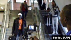 Des agents de santé contrôlent les passagers à l'arrivée avec un scanner thermique à l'aéroport international Blaise Diagne de Dakar, le 30 janvier 2020. (Seyllou / AFP)