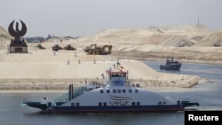 The ship 'Long Life Egypt' crosses a new section of the Suez Canal in Ismailia, Egypt, Aug. 6, 2015. The canal was extended in hopes of powering an economic turnaround. But toll revenues have fallen in September, dampening hopes that a new parallel waterway will boost the economy in the immediate future.