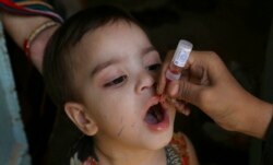 FILE - A health worker administers a polio vaccine to a child in Karachi, Pakistan, Sept. 20, 2021.
