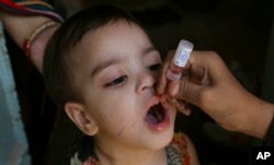 FILE - A health worker administers a polio vaccine to a child in Karachi, Pakistan, Sept. 20, 2021.