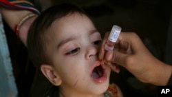 FILE - A health worker administers a polio vaccine to a child in Karachi, Pakistan, Sept. 20, 2021. In 1979, polio was declared eliminated in the U.S., meaning there was no longer routine spread. Rarely, travelers have brought polio infections into the U.S.