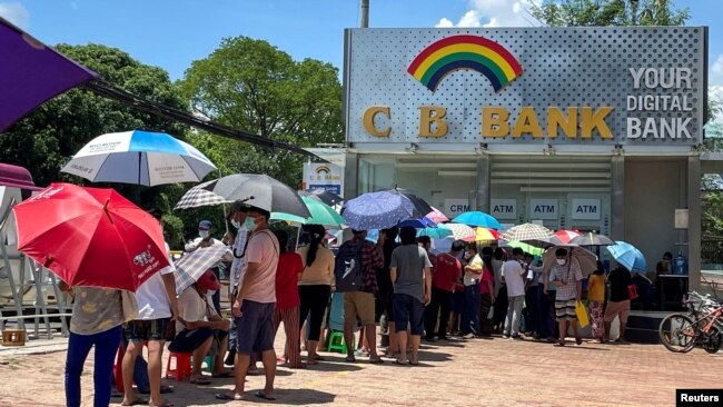FILE - People line up outside a bank to withdraw cash, in Yangon, Myanmar, May 13, 2021.