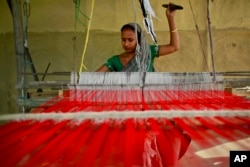 FILE - An Indian woman weaves at Panbari village in northeastern Assam state, India, April 12, 2016.