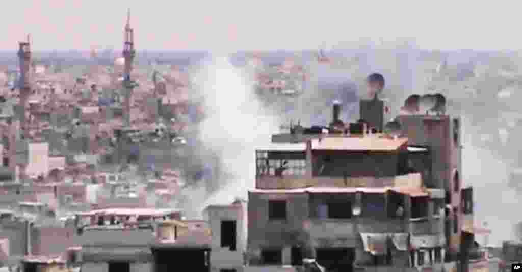 This image made from amateur video purports to show smoke rising from buildings in Homs, Syria. Syrian forces renewed shelling of the central city of Homs on Monday, one day after the head of the U.N. observers' mission demanded that warring parties allow