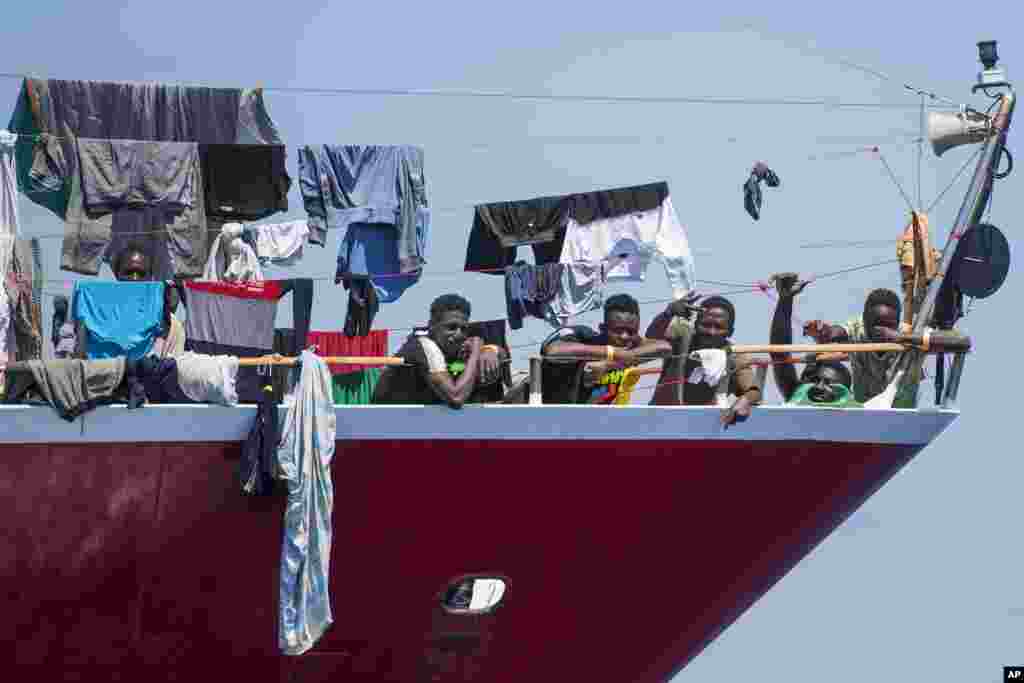 Migrants dry their clothes aboard a tourist boats some 20 kilometers from Malta.