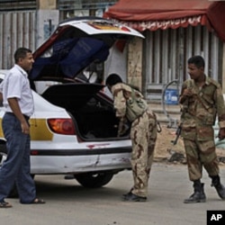 Yemeni army soldiers, check a car, at a checkpoint in Sana'a, June 11, 2011