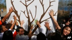 Ambientalistas hicieron simbólicas impresiones de las manos en una pared con la imagen de un árbol para conmemorar el Día de la Tierra el viernes, 22 de abril de 2016, en un suburbio al sur de Manila, Filipinas.