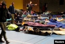 Migrants sleep in a gym after a big fire which destroyed many wood houses at a camp for migrants in Grande-Synthe near Dunkirk, France, April 11, 2017.