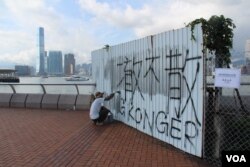 工人正在覆盖抗争者2019年6月29日凌晨占领时喷涂的标语(美国之音申华拍摄)
