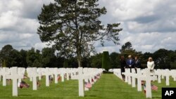 President Donald Trump, first lady Melania Trump, French President Emmanuel Macron and Brigitte Macron, walk through The Normandy American Cemetery, following a ceremony to commemorate the 75th anniversary of D-Day, June 6, 2019, in Colleville-sur-Mer, No