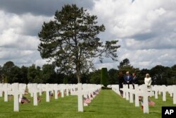 President Donald Trump, first lady Melania Trump, French President Emmanuel Macron and Brigitte Macron, walk through The Normandy American Cemetery, following a ceremony to commemorate the 75th anniversary of D-Day, June 6, 2019, in Colleville-sur-Mer, No