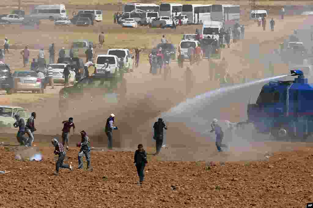 Riot police use water cannons to disperse Kurdish demonstrators who were clashing with Turkish security forces, as thousands of Syrian refugees continue to arrive at the border in Suruc, Turkey, Sept. 22, 2014.