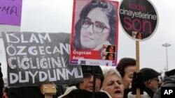 A Turkish woman holds a poster of murdered 20-year-old student Ozgecan Aslan at a protest in Ankara Feb. 18, 2015. The placards read: "End the killings of women" and "Islam (Aysenur Islam, Family Affiars minister), did you hear Ozgecan's scream?"