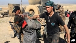 FILE - Iraqi special forces arrest a suspected Islamic State fighter in Mosul, Iraq, Feb. 25, 2017.