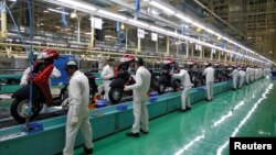 Employees work on an assembly line of Honda Motorcycle & Scooter India in Vithalapur in the western state of Gujarat, India, Feb. 17, 2016. 
