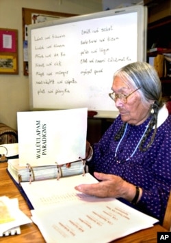 In this file photo, Umatilla elder, the late Cecilia Bearchum goes over a large binder used to teach Walla Walla, a critically endangered language spoken at the Umatilla Indian Reservation, Ore., March 6, 2002. Ms. Bearcham passed away April 18, 2011 at