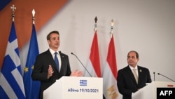 Presiden Mesir Abdel Fattah El-Sisi (kanan) dan Perdana Menteri Yunani Kyriakos Mitsotakis (kiri) dalam konferensi pers seusai pertemuan trilateral antara Yunani, Mesir dan Siprus, di Athena, 19 Oktober 2021. (ARIS MESSINIS / AFP)