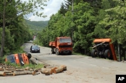 Automobil prolazi pored kamiona koji su poslužili kao barikade, nakon što je Kosovska policija rasčistila put u blizini Zubinog Potoka, na severozapadu Kosova, 28. maja 2019.