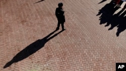 A security officer watches the crowd in a plaza, Feb. 6, 2014, in Rosa Khutor, Russia. The area will host the alpine events at the 2014 Winter Olympics.