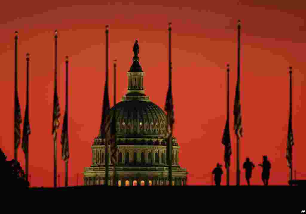 Bendera-bendera AS dikibarkan setengah tiang di sekitar Monumen&nbsp;Washington dengan latar belakang kubah gedung Capitol di Washington DC, untuk mengenang para korban penembakan di Las Vegas.