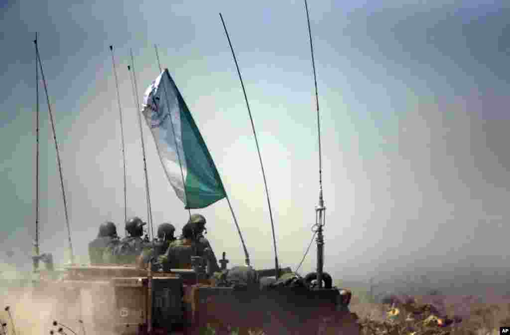Israeli soldiers on an armored personnel carrier move to a new position on the Israel-Gaza Border, July 12, 2014. 