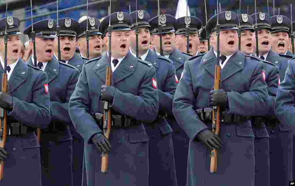 Polish soldiers salute during the the 97th anniversary of Independence Day ceremonies in Warsaw.