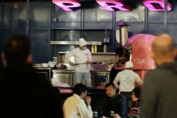 Seorang penjual menyiapkan pizza di sebuah food truck di Al Aali Mall di Manama, Bahrain, di tengah pandemi COVID-19, 27 Februari 2021. (REUTERS)